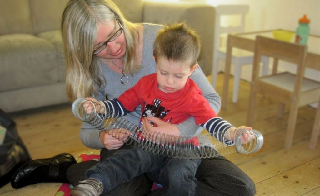 Anna Koppenhout speech and language therapist using a slinky to encourage interaction with a child