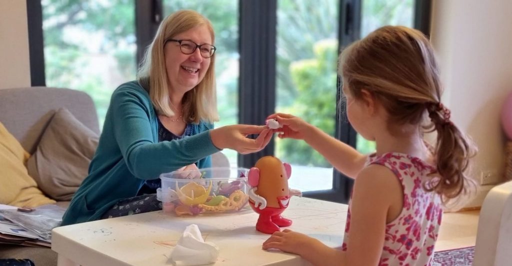 Speech and language therapist working with child.